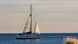 Sailboat on calm open water at sunset.