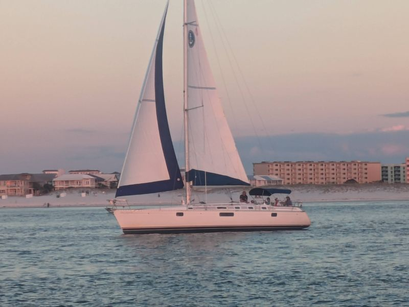 East Pass Sailing charter sailing across emerald Gulf waters under clear coastal skies.