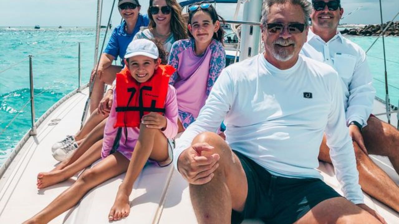 Family on board a private sailing charter with calm sea in background