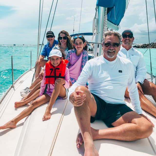 Family members relaxing and enjoying a sailing charter experience on a boat
